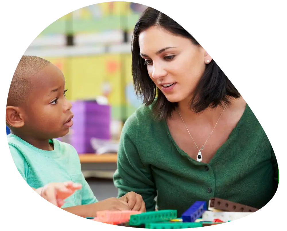 a nursery teacher guiding a kid a nursery teacher guiding a kid